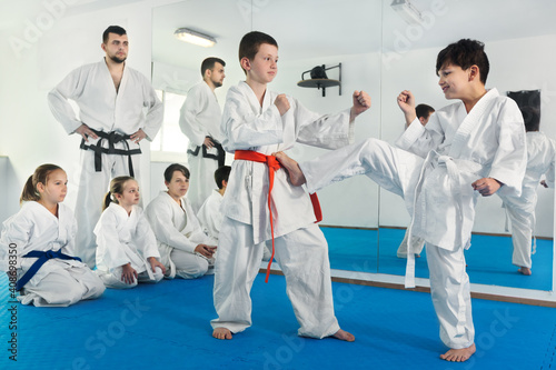 Pair of little boys practicing new karate moves during the class