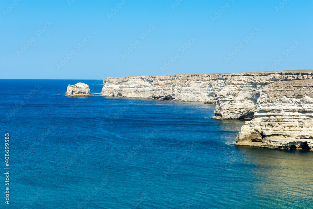 Beautiful view of blue sea and mountain. Calm water in bay with rock, sunny day