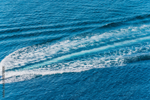 Trail on water surface behind of fast moving motor boat