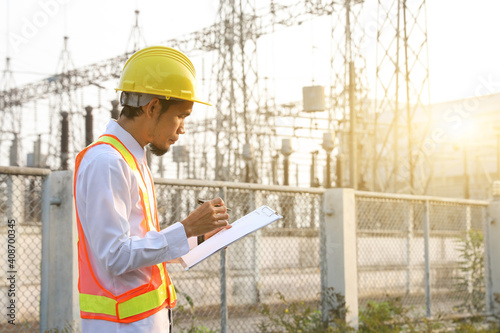 Engineers are reviewing and taking notes of electrical operation reports.
