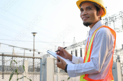 Engineers are reviewing and taking notes of electrical operation reports.