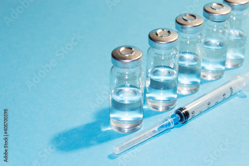Vaccination against viruses. COVID 19 coronavirus vaccine. Glass vials with injection solution, syringe. Copy space.