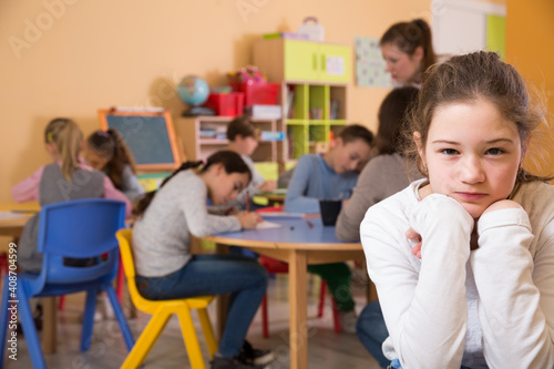 Portrait of schoolgirl and children drawing in classroom