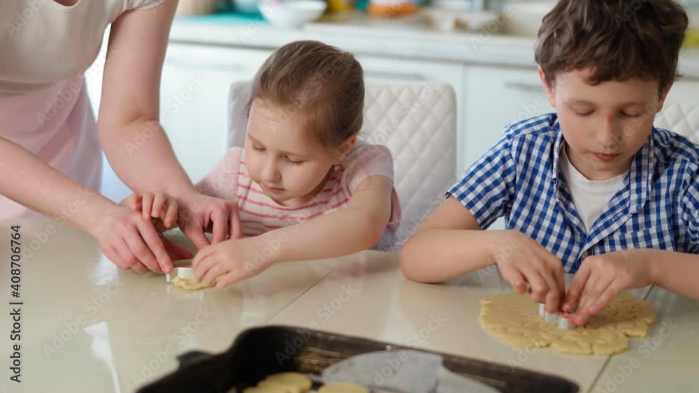 Children and mother bake cookies. close-up with their hands, a boy and a girl cut cookie molds out of the dough using cookie cutters and put them on a baking sheet in the kitchen. 4K Video Children and mother bake cookies. close-up with their hands, a boy and a girl cut cookie molds out of the dough using cookie cutters and put them on a baking sheet in the kitchen. 4K Video