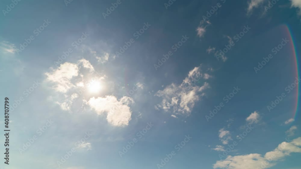 Time Lapse 4K beautiful sunny blue sky with bright sun light shining through white clouds & cumulus cloudscape in tropical summer landscape or spring sunlight with sunbeam & sun ray flares over clouds