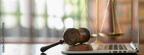 law legal technology concept.  judge gavel on computer with scales of justice on desk of lawyer.