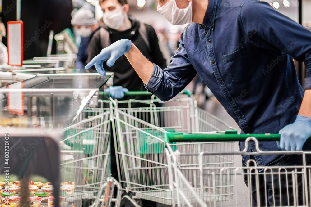 customer in protective gloves choosing products in a supermarket.