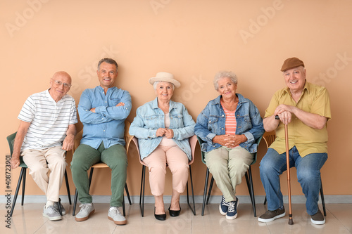 Senior people sitting on chairs in room