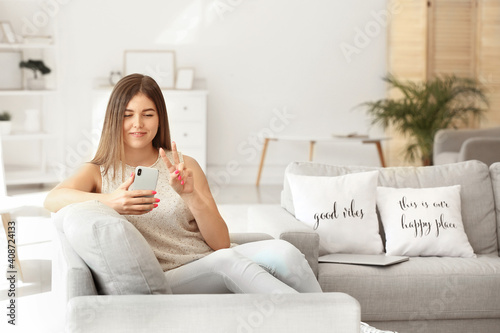 Young woman sitting on sofa...