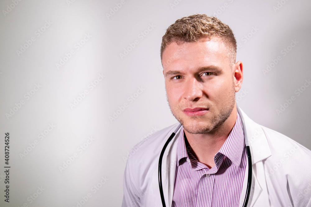 Serious handsome male doctor wearing white lab coat looking at camera Serious handsome male doctor wearing white lab coat looking at camera