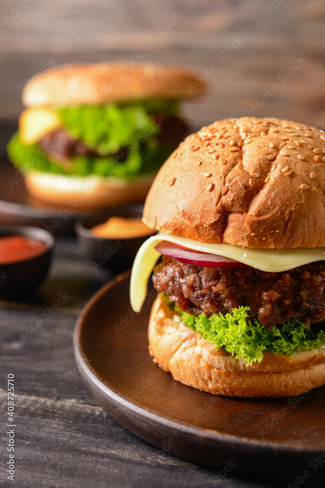 Tasty burgers on dark wooden background, closeup