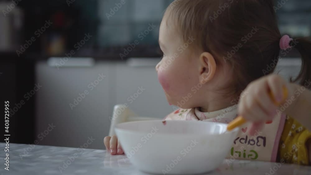 Cute child eating. Baby girl eating healthy food herself. Toddler smiling. Cute child eating. Baby girl eating healthy food herself. Toddler smiling.