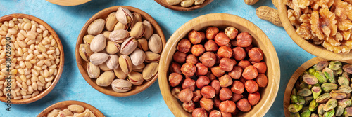 Nuts variety panoramic banner. Hazelnuts, pistachios, pine nuts and walnuts, top shot