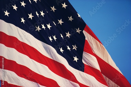 American flag blowing in the wind against the blue sky
