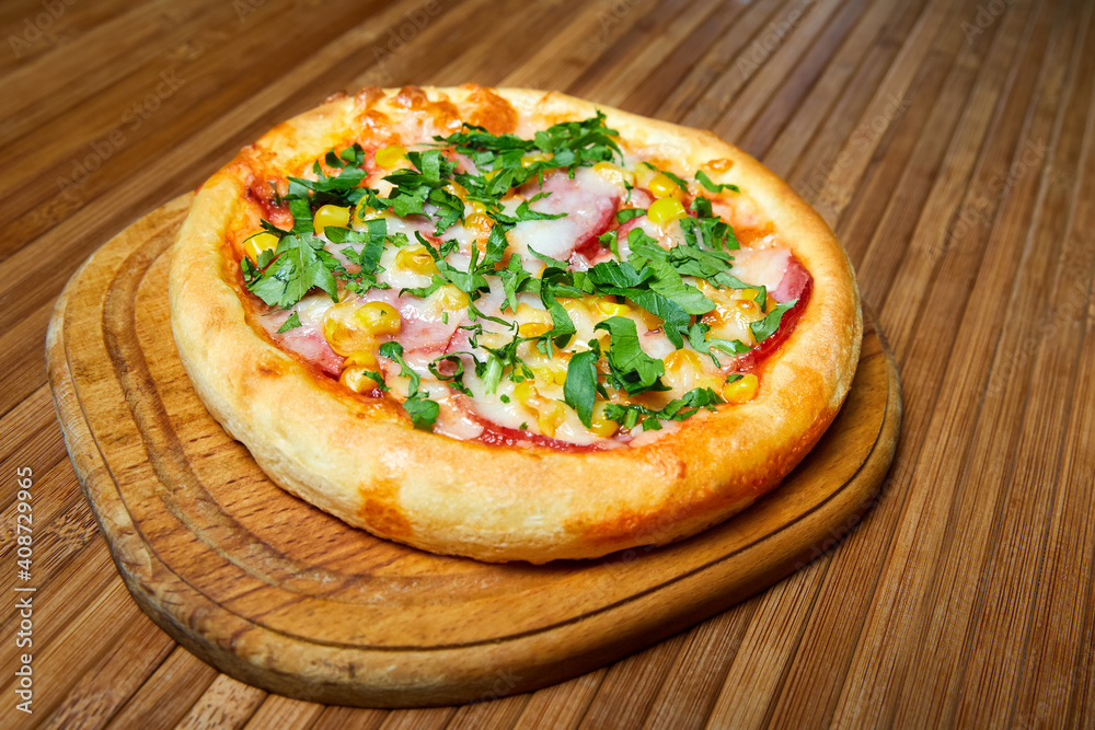 Pizza with cheese, bacon and herbs on a wooden plate. Close-up, selective focus Pizza with cheese, bacon and herbs on a wooden plate. Close-up, selective focus