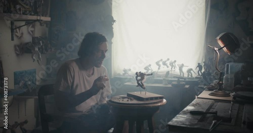 Wallpaper Mural Artist smoke cigarette look at skateboarder sculpture in dark atelier Torontodigital.ca