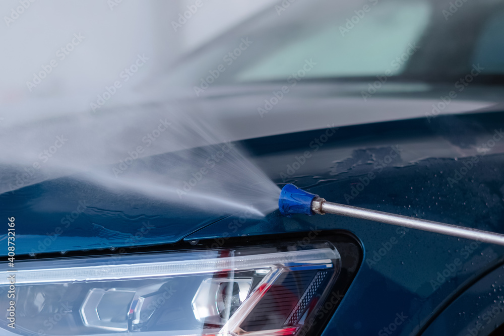Obraz premium Close up of washing the car with high pressure water at self service car wash.