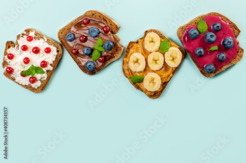 Homemade open sweet sandwiches on blue background. Top view, copy space. 