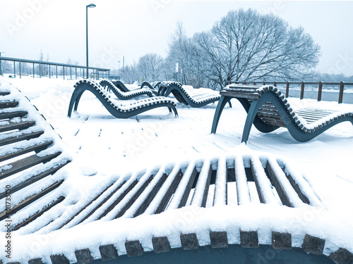 Snow-covered chaise-longues in a park in Moscow