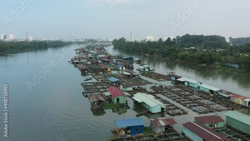 slow tracking drone shot over floating fish farming community in Bien Hoa on the Dong Nai river, Vietnam on a sunny day photo