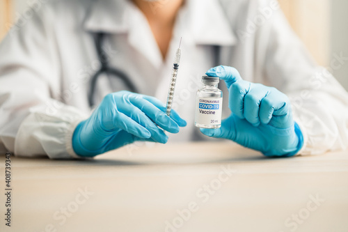 doctors or scientists show the coronavirus vaccine (COVID-19) and a syringe in laboratory room, concept for research and development of a vaccine against pathogens.