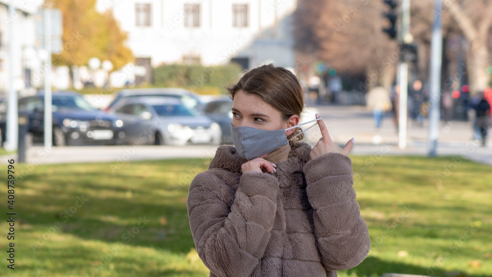 Beautiful stylish girl wear medical face mask on sunny city street. Young elegant happy hipster woman put on protective face mask outdoors. Urban fashion outfit, lifestyle. COVID-19 quarantine, travel Beautiful stylish girl wear medical face mask on sunny city street. Young elegant happy hipster woman put on protective face mask outdoors. Urban fashion outfit, lifestyle. COVID-19 quarantine, travel