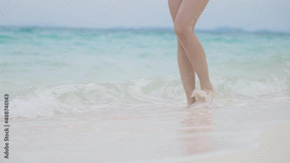 woman legs wear walking on blue sea wavy beach, exploring nature paradise private island, exotic Adventure Traveling on tropical island, season climate changes, strong waves, get ready for surfing woman legs wear walking on blue sea wavy beach, exploring nature paradise private island, exotic Adventure Traveling on tropical island, season climate changes, strong waves, get ready for surfing