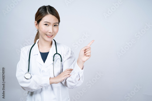 Portrait of Asian woman doctor wearing uniform stand isolated on white studio background.