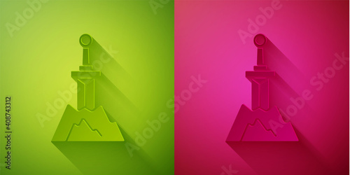 Paper cut Sword in the stone icon isolated on green and pink background. Excalibur the sword in the stone from the Arthurian legends. Paper art style. Vector.