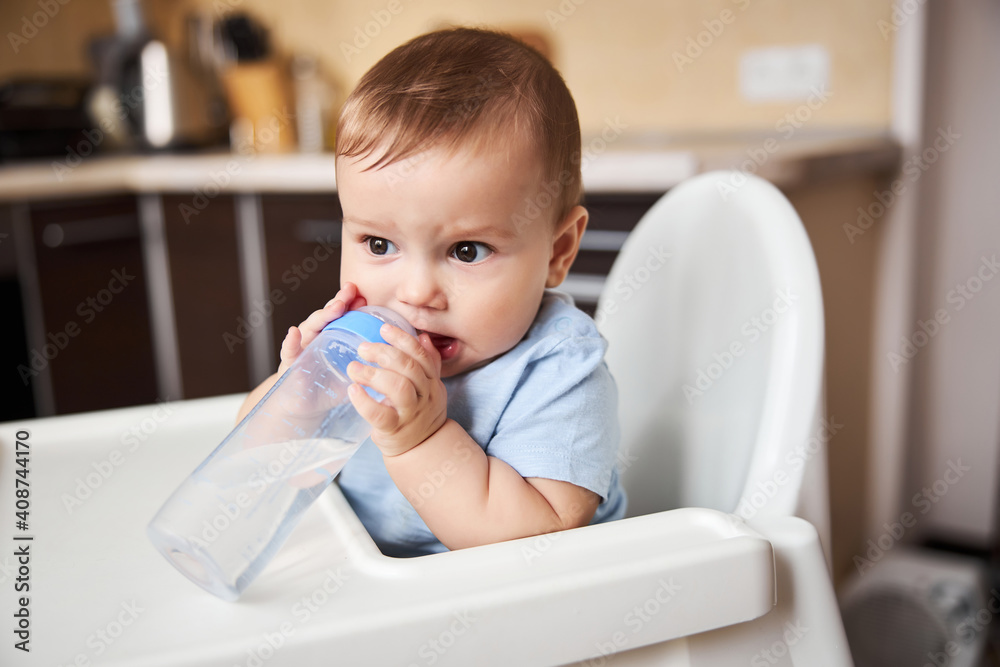 Serious little boy biting nipple on the bottle Serious little boy biting nipple on the bottle