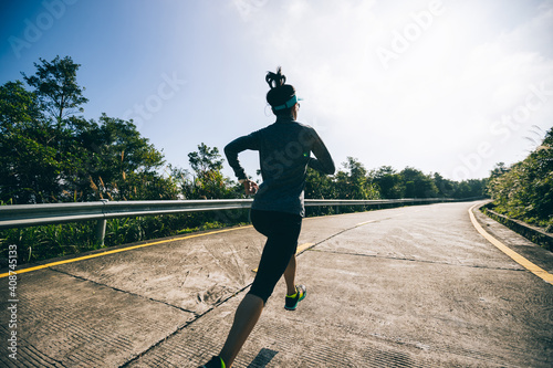 Woman trail runner cross country running in winter mountains