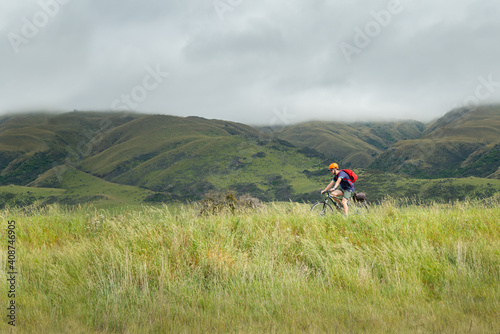 A young man cycling the Otago Central Rail Trail between Hyde and Middlemarch, South Island, New Zealand photo