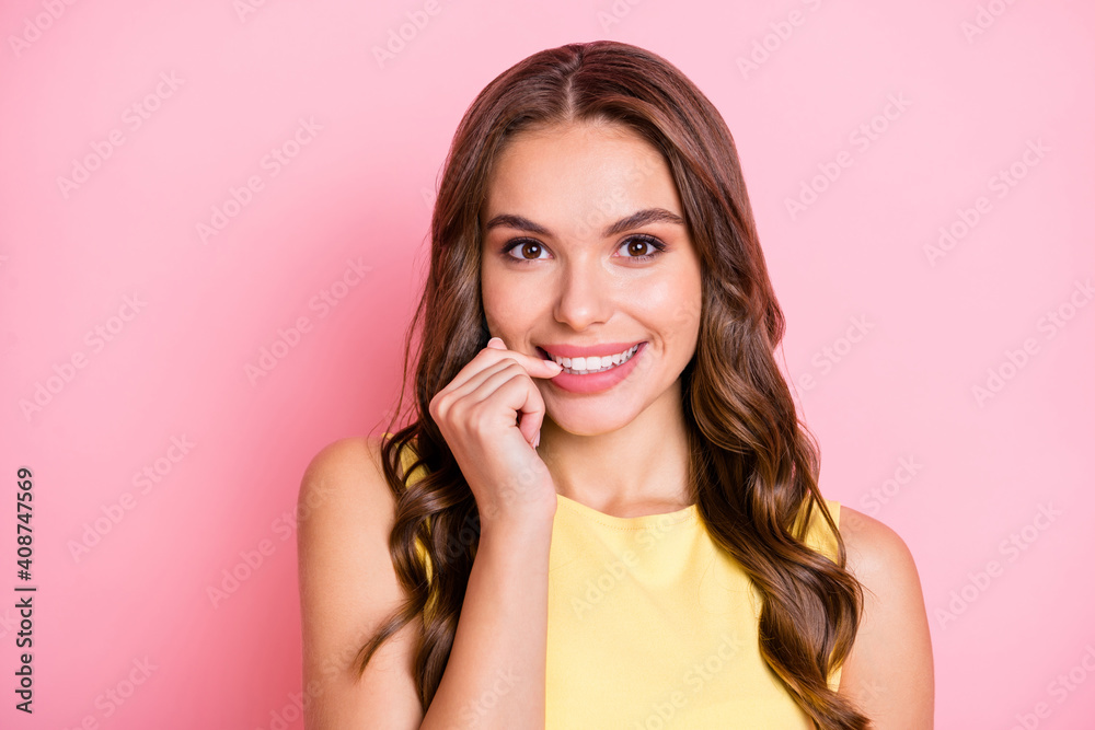 Portrait of cute curly hairstyle positive person biting nail beaming smile isolated on pink color background Portrait of cute curly hairstyle positive person biting nail beaming smile isolated on pink color background