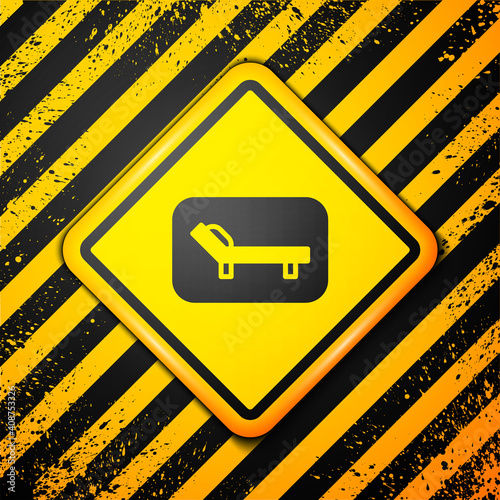 Black Sunbed icon isolated on yellow background. Sun lounger. Warning sign. Vector.