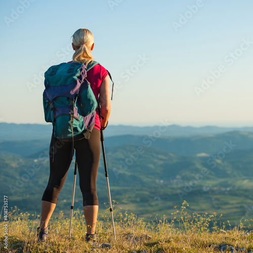 Woman on trekking - Beautiful blonde girl hiking on mountains Stock Photo