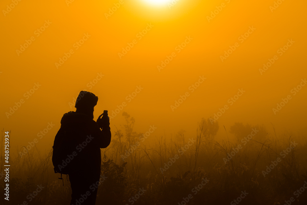 silhouette of man take photo view sunrise in the mountain by smartphone