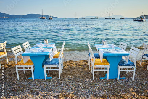 Cute chairs and table on the beach at seaside restaurant in Bodrum