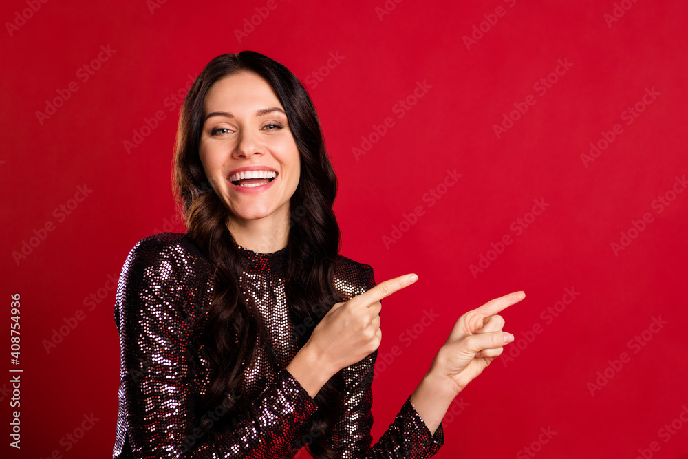 Fototapeta premium Portrait of positive charming girl direct fingers empty space proposition isolated on red color background