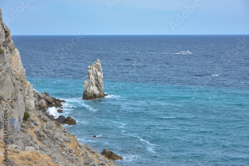 a piece of rock near the sea near the coast, a view of the coastal rocks near the castle Swallow's Nest in Crimea, a detached large piece of rock in the middle, coastline on the left, sea view