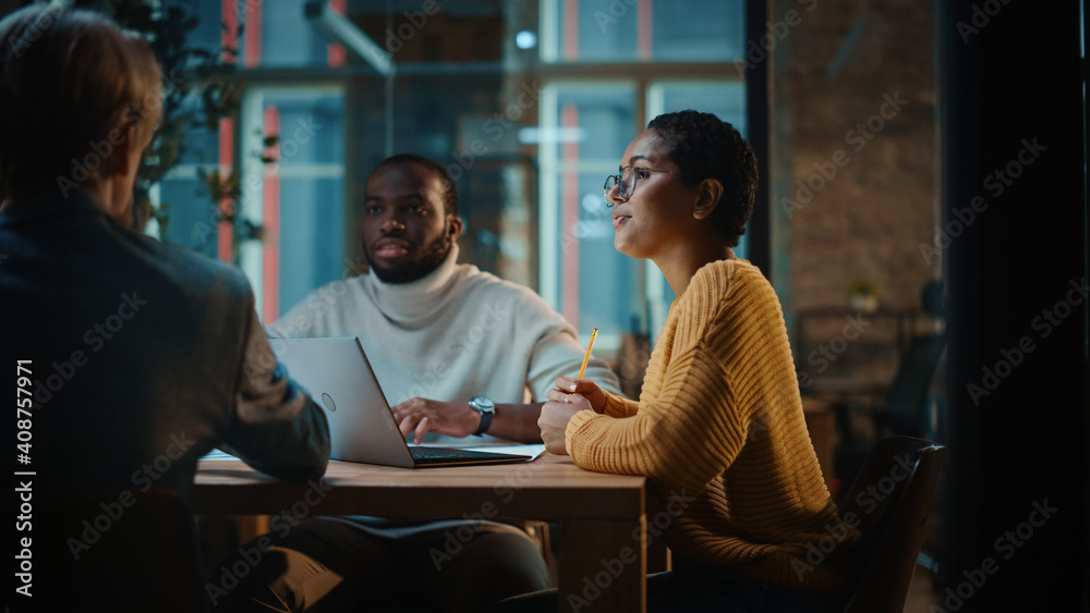 © Gorodenkoff - Young Creative Team Meeting with Business Partners in Conference Room Behind Glass Walls in an Agency. Colleagues Sit Behind Conference Table and Discuss Business, App User Interface and Design.