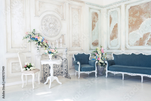 Bright luxury white and blue colored interior living room with flowers in vases. the walls are decorated with baroque ornaments © 4595886