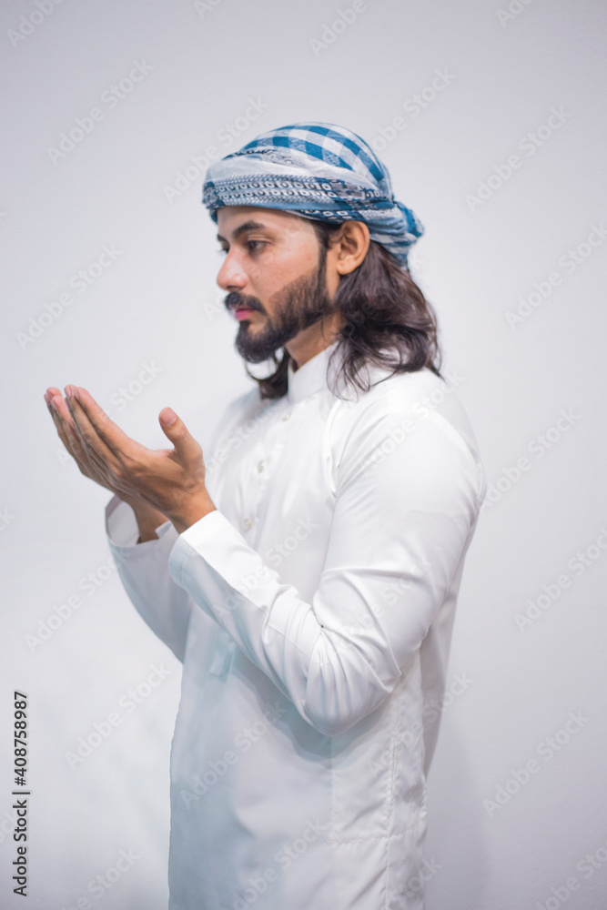 Religious muslim man praying on grey background Religious muslim man praying on grey background