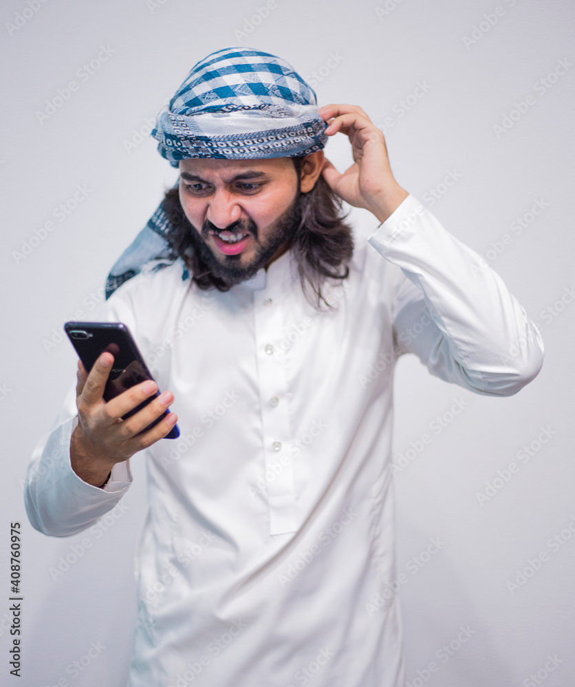 Religious man watching social media in the smart phone isolated on a grey background Religious man watching social media in the smart phone isolated on a grey background