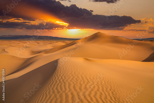 Sunset over the sand dunes in the desert. Arid landscape of the Sahara desert