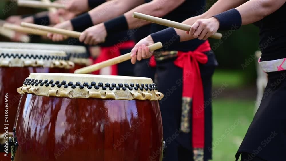 Group of Taiko drummers drumming on Japanese Drums