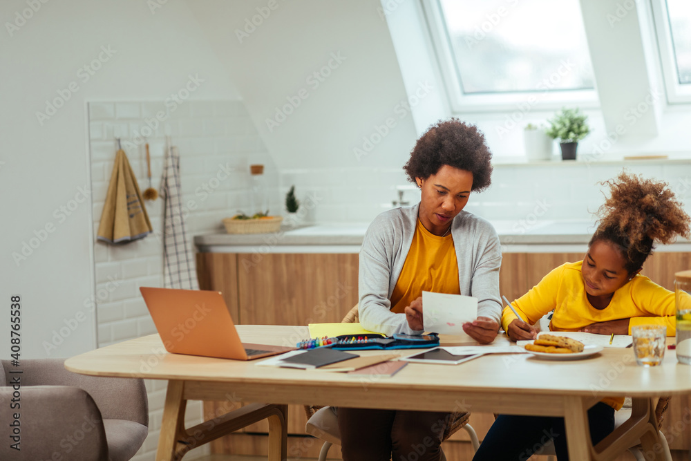 Afro mother assisting her daughter with homework Afro mother assisting her daughter with homework