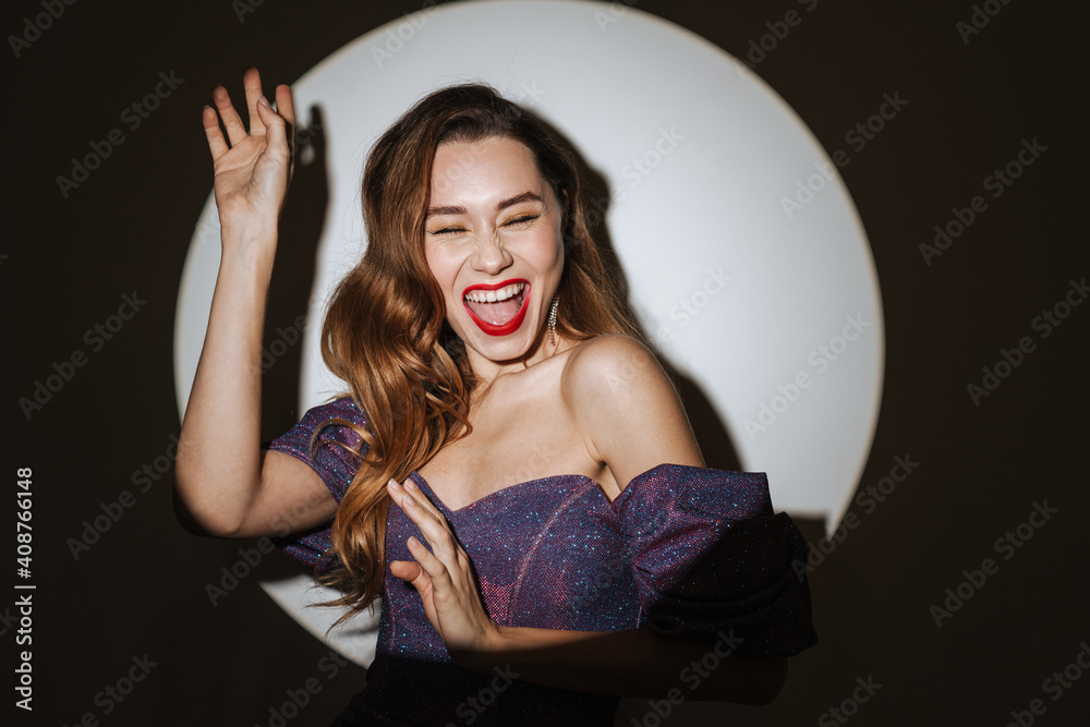 Excited beautiful girl in evening dress laughing and dancing Excited beautiful girl in evening dress laughing and dancing
