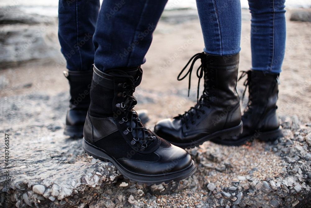 Guy and a girl in the mountains are yelling in black boots