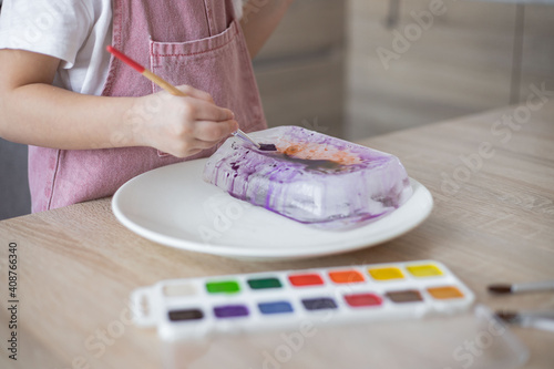 Child painting ice block, fantastic chilly sensory activity and art for preschoolers and toddlers.