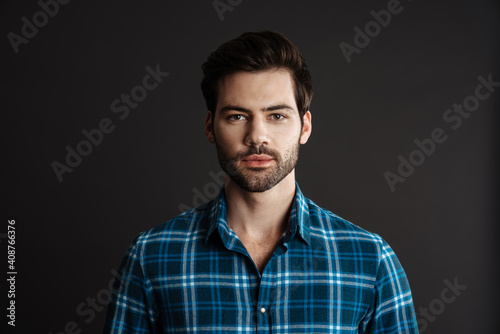Brunette handsome unshaven guy posing and looking at camera